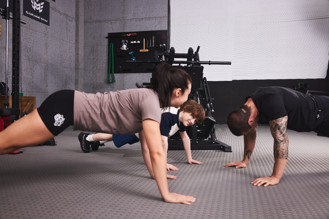Family engaging in push-up exercises in their home gym.
