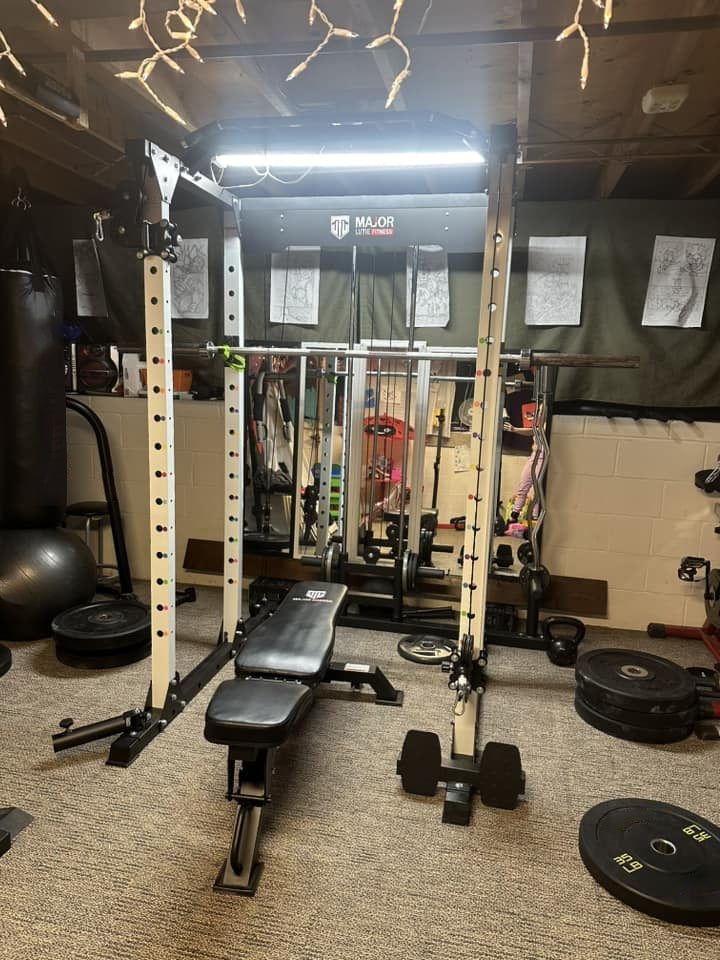 basement home gym setup with bench, power rack PLM03, and weights.