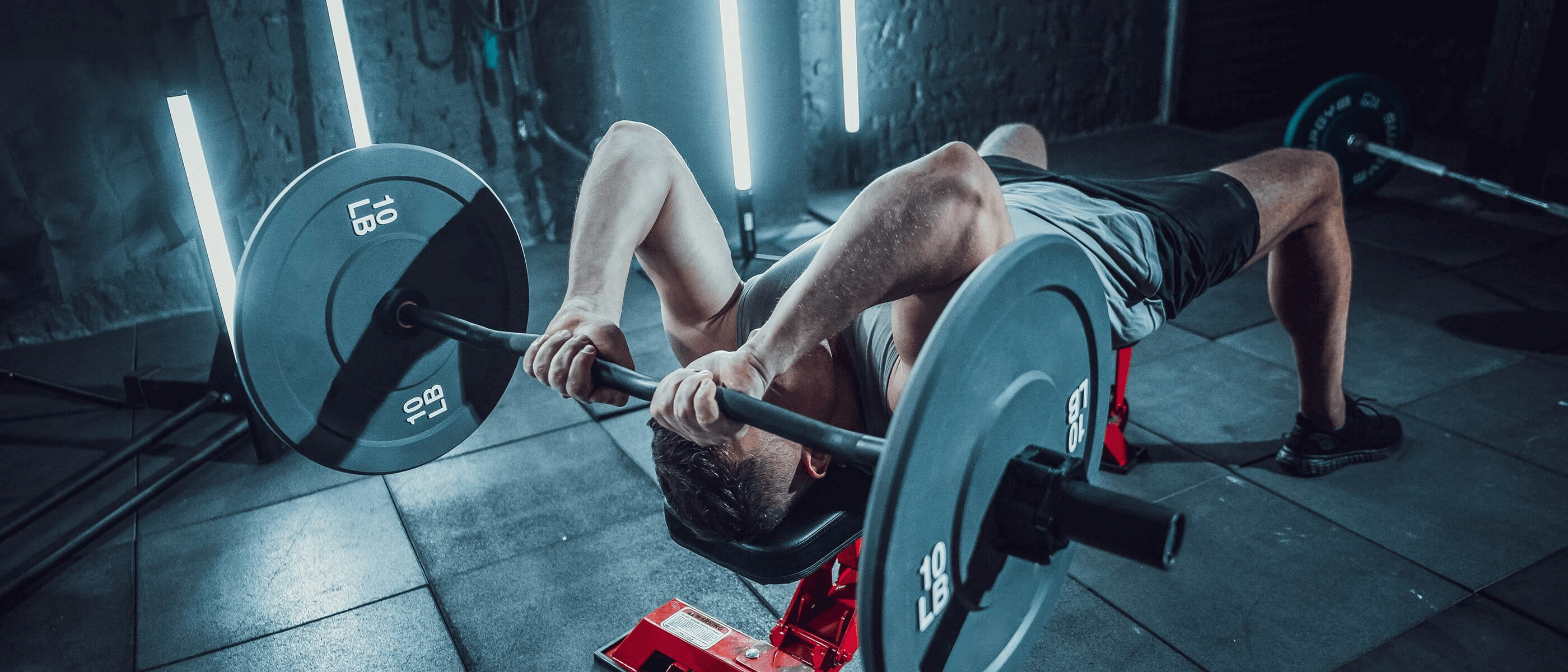 man doing bench press at home gym