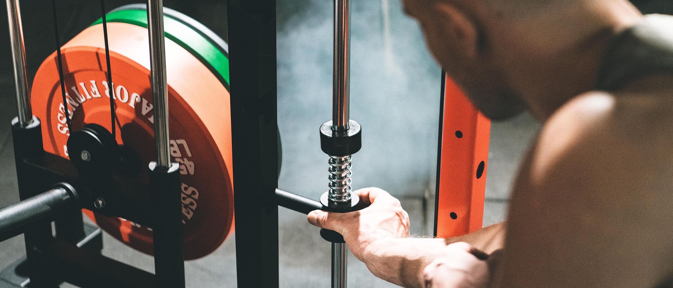 a hand adjusting the weight pin on gym equipment
