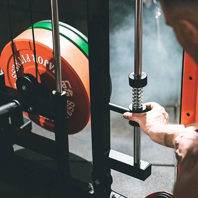 a hand adjusting the weight pin on smith machine