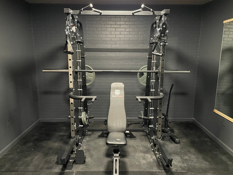 Multi-functional home gym smith machine with pull-up bar in a room with black brick walls